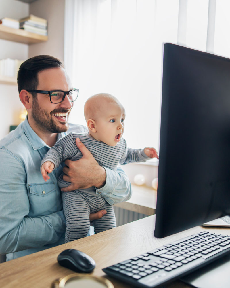 A young father enjoys a new desktop computer from Quickstart